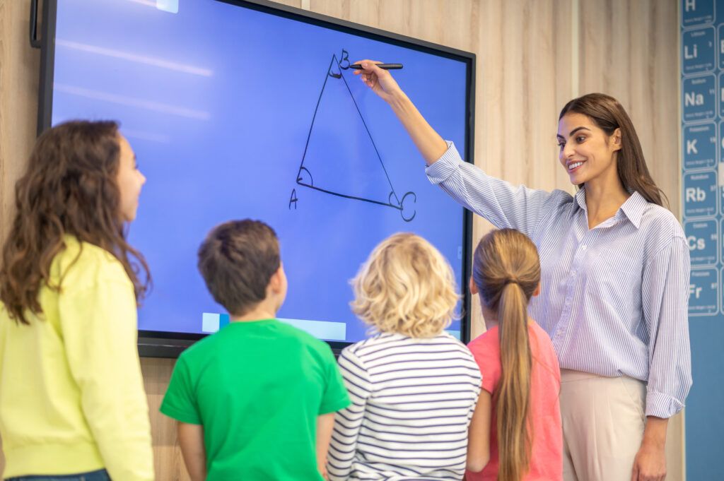 woman-drawing-showing-triangle-blackboard-children-1024x681.jpg