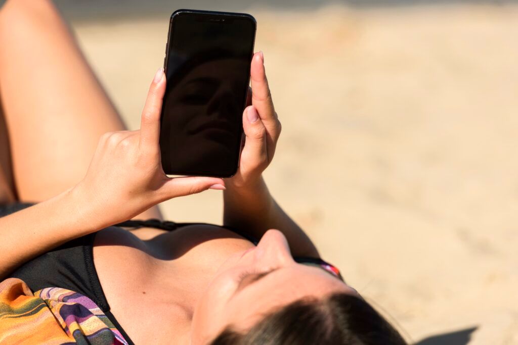 woman-beach-holding-smartphone-1024x683.jpg
