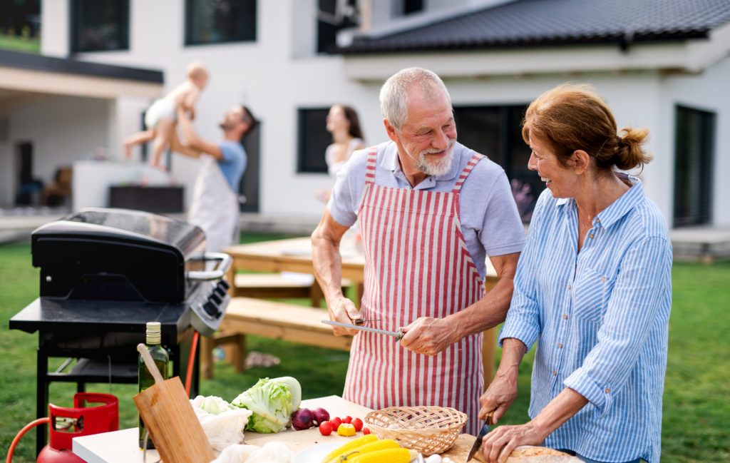 front-view-senior-couple-with-family-outdoors-garden-barbecue-grilling-1-1024x649.jpg