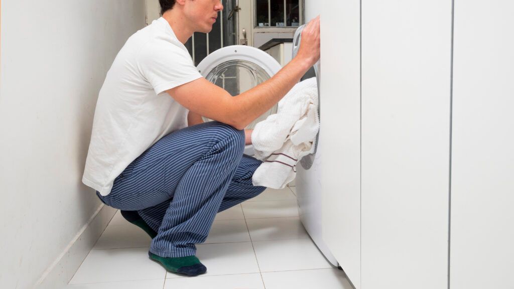 close-up-man-putting-clothes-washing-machine-1024x576.jpg
