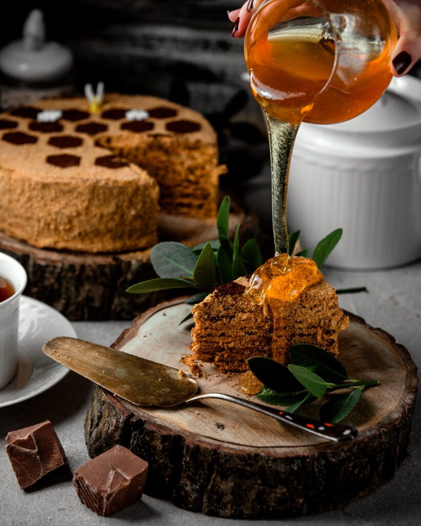 woman-pouring-honey-honey-cake-with-chocolate-cream-821x1024.jpg