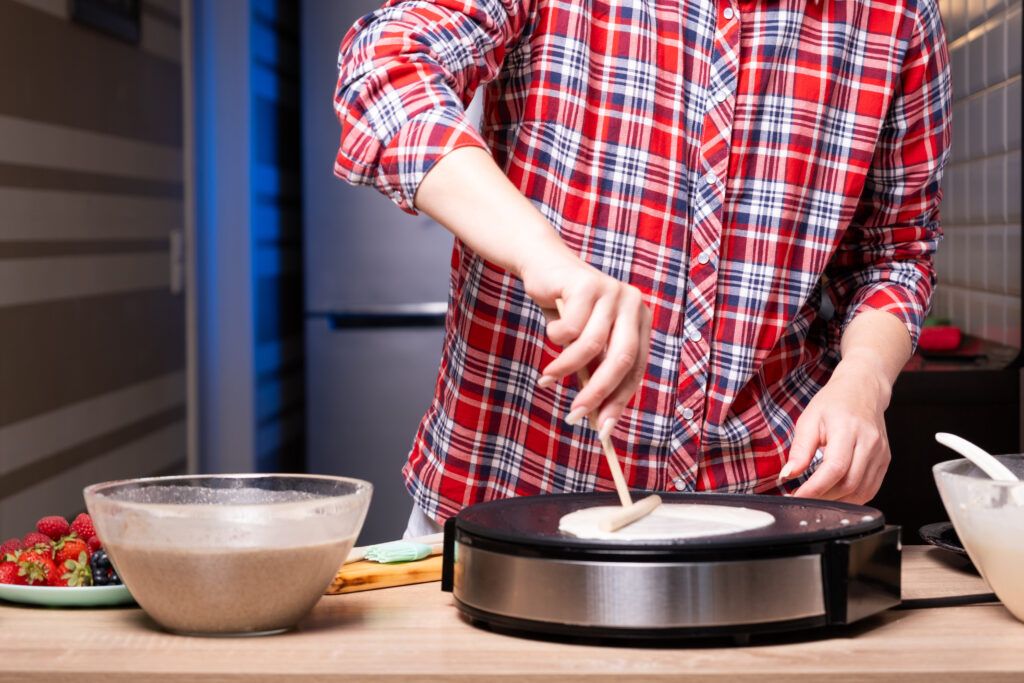 woman-cooking-delicious-crepe-electric-pancake-maker-kitchen-closeup-1024x683.jpg