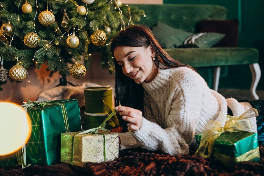 young-woman-by-christmas-tree-unpacking-gifts-1024x683.jpg