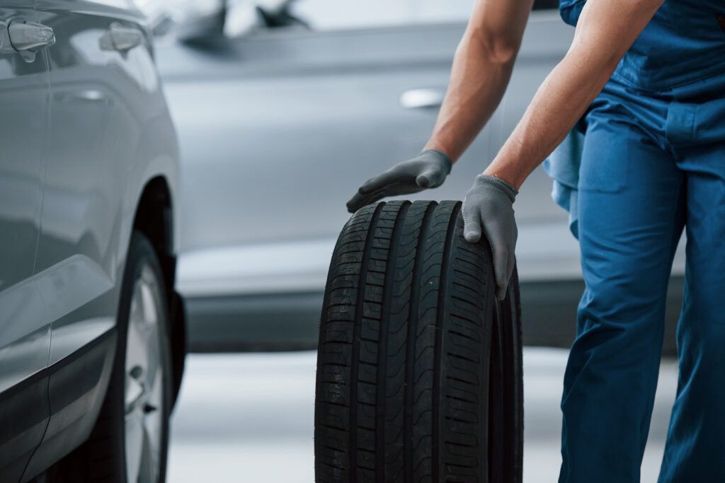 business-car-repairing-mechanic-holding-tire-repair-garage-replacement-winter-summer-tires-1024x683.jpg