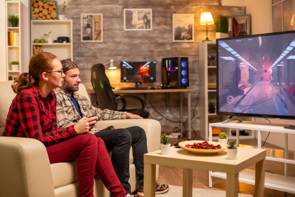 couple-playing-video-games-big-screen-tv-living-room-late-night-1024x683.jpg