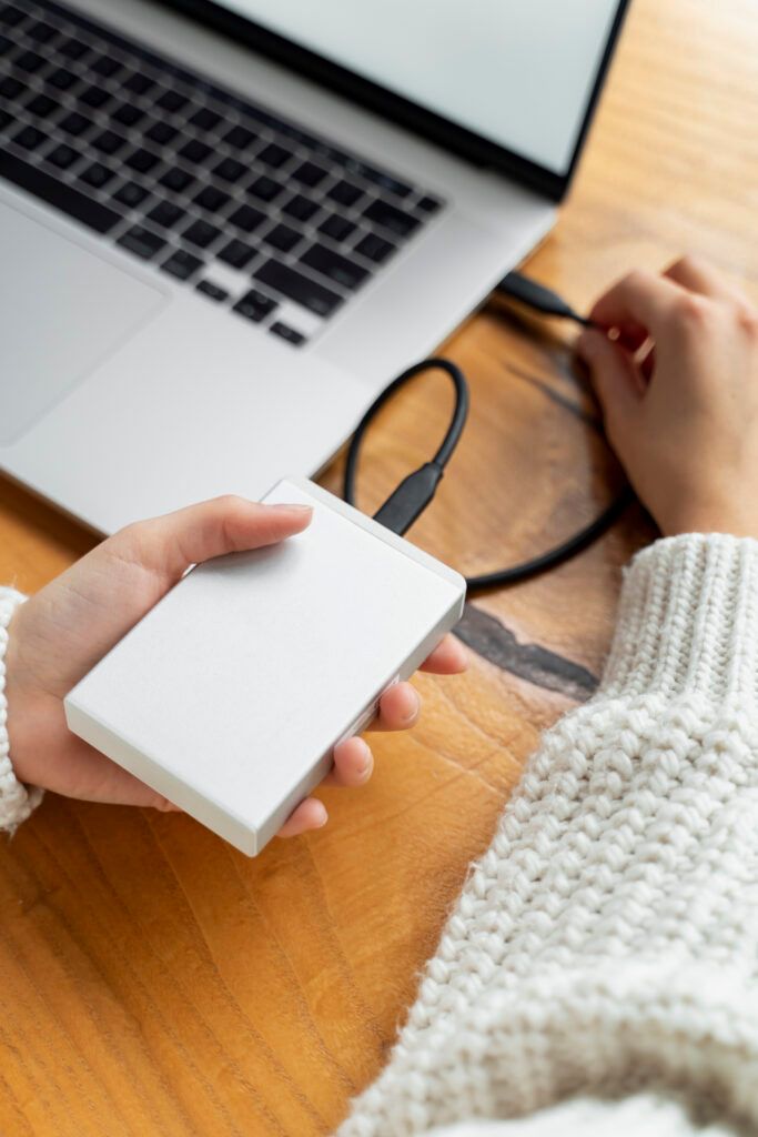high-angle-hands-connecting-ssd-laptop-683x1024.jpg